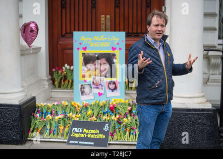 Richard Ratcliffe, der Ehemann der Britischen liebe Nazanin Zaghari-Ratcliffe Arbeiter, die in Iran abgehalten wird, wo sie der Spionage beschuldigt wird, mit einem riesigen MotherÕs Tag Karte und Blumen auf den Stufen der iranischen Botschaft in Knightsbridge, London, als er zur Kampagne für die Freigabe seiner Frau fort. Stockfoto