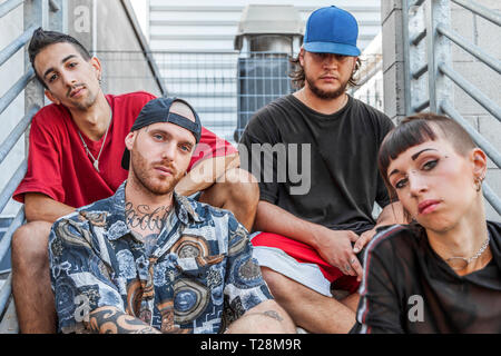 Gruppe von jungen Rapper posing sitzen auf dem Metall Treppe von einem verlassenen Gebäude Stockfoto