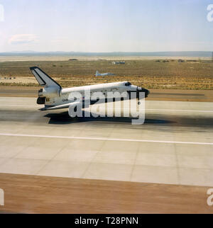 (4 Juli 1982) - - - Die hinteren Räder des Space Shuttle Columbia leicht nach unten auf der Landebahn von der Edwards Air Force Base (AFB) hat heute erfolgreich eine Woche lang Raumfahrt Astronauten Thomas K. Mattingly II abzuschließen, und Henry W. Hartsfield jr. ein T-38 Flugzeuge als chase Ebene (knapp über dem Zentrum von Foto) im Hintergrund dient. Stockfoto