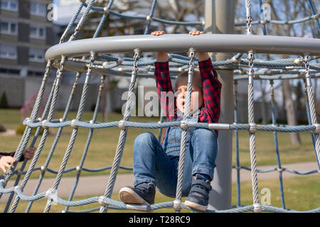 Little Boy in Gap klettern auf Jungle Gym im Park. Stockfoto