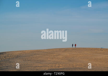 Silhouette Menschen wandern auf der Spitze einer riesigen Düne an der Jockey's Ridge State Park in North Carolina Stockfoto