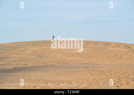 Silhouette Menschen wandern auf der Spitze einer riesigen Düne an der Jockey's Ridge State Park in North Carolina Stockfoto