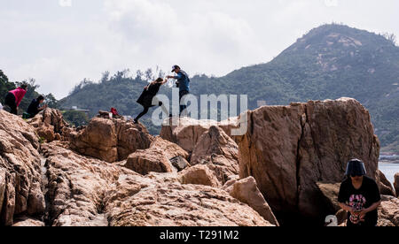 Gruppe von Menschen Felsen Erkundung von Meer, im Küstenort Stanley, Hong Kong Stockfoto