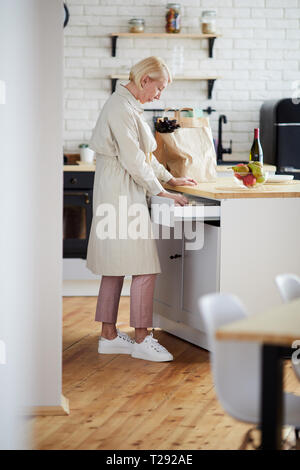 Frau finden Utensil in der küchenschublade Stockfoto