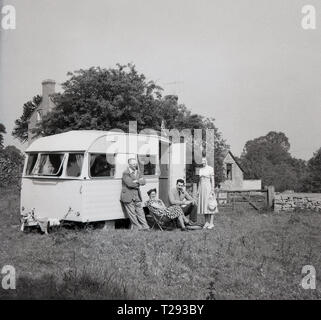 1950, historische, Familie außerhalb ihres Wohnwagen der Ära allein in einem Feld geparkt, England, UK. Stockfoto