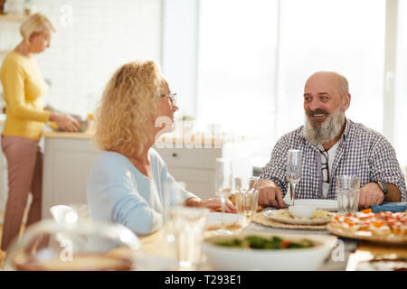 Jolly Freunde sprechen beim Warten auf das Abendessen Stockfoto