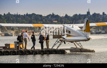 SEATTLE, WA, USA - JUNI 2018: Fluggäste eine De Havilland Beaver Wasserflugzeug von Kenmore Air auf dem Wasserflugzeug terminal in Seattle Betrieben Stockfoto