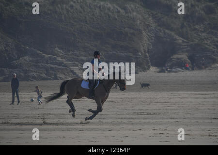 Perranporth, Cornwall, UK. 31. März 2019. UK Wetter. Es war heiß und sonnig, für den ersten Tag des britischen Sommer am Strand von Perranporth, mit Pferd, Reiter, Wanderer und Familien bei, das heiße Wetter am Muttertag. Foto: Simon Maycock/Alamy leben Nachrichten Stockfoto