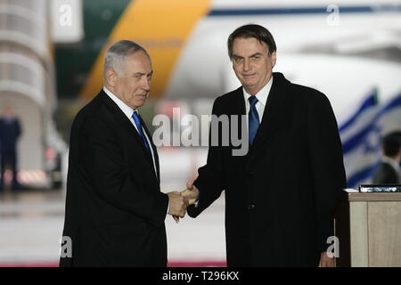 Tel Aviv, Israel. 31 Mär, 2019. Der brasilianische Präsident Jair Bolsonaro (R) schüttelt Hände mit dem israelischen Ministerpräsidenten Benjamin Netanjahu während der Begrüßungszeremonie auf dem Flughafen Ben Gurion in der Nähe von Tel Aviv, Israel, am 31. März 2019. Bolsonaro landete in Israel am Sonntag zu einem offiziellen Besuch, wo er erwartet wurde, bekannt zu geben, ob er der Botschaft seines Landes von Tel Aviv nach Jerusalem verlegen. Credit: Tomer Neuberg - JINI/Xinhua/Alamy leben Nachrichten Stockfoto