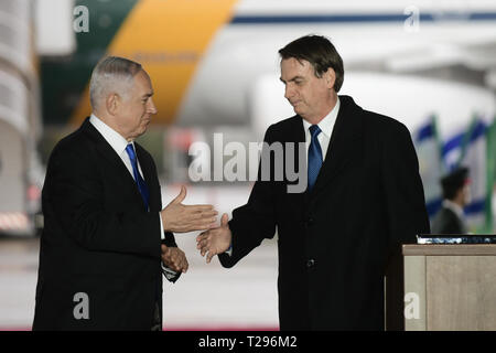 Tel Aviv, Israel. 31 Mär, 2019. Der brasilianische Präsident Jair Bolsonaro (R) schüttelt Hände mit dem israelischen Ministerpräsidenten Benjamin Netanjahu während der Begrüßungszeremonie auf dem Flughafen Ben Gurion in der Nähe von Tel Aviv, Israel, am 31. März 2019. Bolsonaro landete in Israel am Sonntag zu einem offiziellen Besuch, wo er erwartet wurde, bekannt zu geben, ob er der Botschaft seines Landes von Tel Aviv nach Jerusalem verlegen. Credit: Tomer Neuberg - JINI/Xinhua/Alamy leben Nachrichten Stockfoto