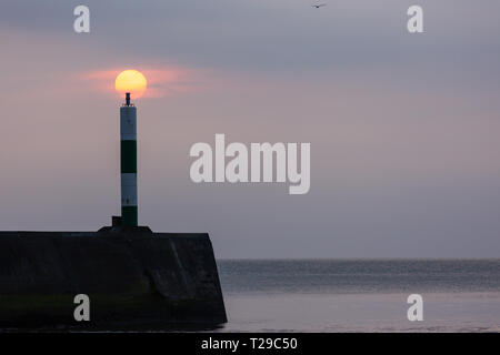 Aberystwyth, Großbritannien. 31. März 2019 Deutschland Wetter: Nach einem ruhigen Tag in Aberystwyth die gedämpften Sonne hinter den Wolken und Leuchtturm an der Westküste. © Ian Jones/Alamy leben Nachrichten Stockfoto