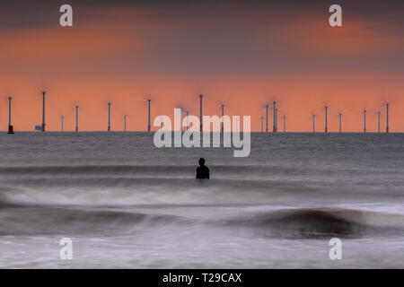 Crosby Strand, UK. März 31, 2019: Crosby, UK. Die Sonne als Wellen um eine von Gusseisen Antony Gormley Statuen auf Crosby Strand an der Sefton Coast abstürzen. Quelle: Christopher Middleton/Alamy leben Nachrichten Stockfoto