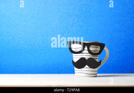 Kaffeebecher mit Schnurrbart auf blauem Hintergrund, Happy Vatertag Konzept Stockfoto