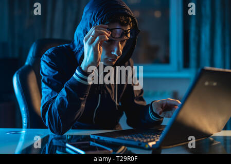 Eine männliche Hacker in Gläsern Nachdenken über das Problem der Hacking und Diebstahl von Access Datenbanken mit Passwörtern. Das Konzept der Cybersicherheit Stockfoto