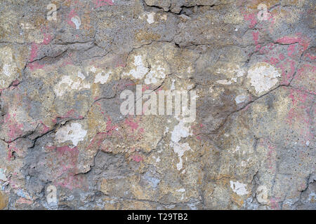 Alte verputzte Backsteinmauer mit Rissen und Spuren von Farbe Stockfoto