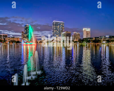 ORLANDO, Florida, USA - Dezember, 2018: bunte Lichter an der Blauen Stunde, nach Sonnenuntergang, bei Eola Lake Park mit dem Brunnen und die Gebäude Reflexionen, Stockfoto