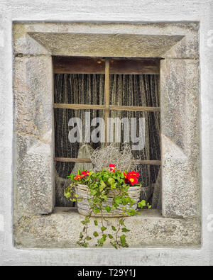 AT - Tirol: alte Stein Fenster mit Blumenkorb in Rattenberg am Inn Stockfoto