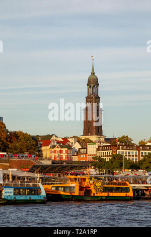 Blick von der Elbe an den St. Pauli Landungsbrücken oder Landungsbrücken und die St. Michael Kirche in Hamburg, Deutschland. Stockfoto