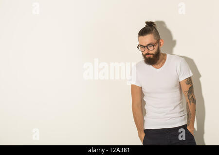 Hipster, Personen Konzept - Tätowiert bärtiger Mann im weißen Hemd auf weißem Hintergrund. Stockfoto