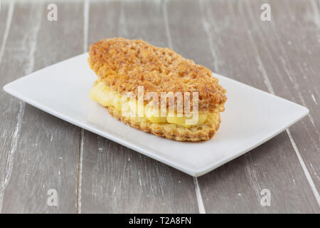 La Lengua de Creu, ist ein centennial Dessert typisch für eine Region von Spanien. Es ist eine exquisite Blätterteig gefüllt mit Vanillepudding und bedeckt mit Zuckerglasur sug Stockfoto