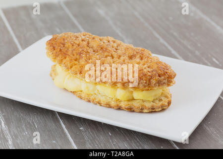 La Lengua de Creu, ist ein centennial Dessert typisch für eine Region von Spanien. Es ist eine exquisite Blätterteig gefüllt mit Vanillepudding und bedeckt mit Zuckerglasur sug Stockfoto