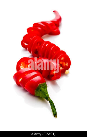 Studio Foto eines roten Paprika in kleine Scheiben, liegend auf einem weißen Hintergrund Stockfoto