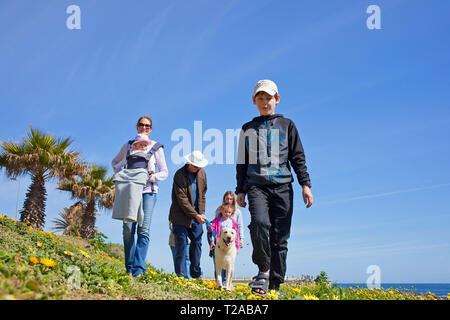 Eine Familie und ihrem Hund zu Fuß entlang der Promenade, Sea Point, Kapstadt. Stockfoto