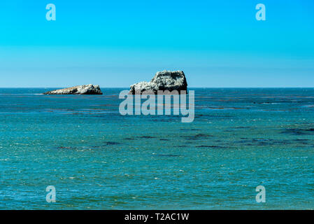 Mit Blick auf den Ozean mit Felsformationen im Meer unter strahlend blauem Himmel. Stockfoto