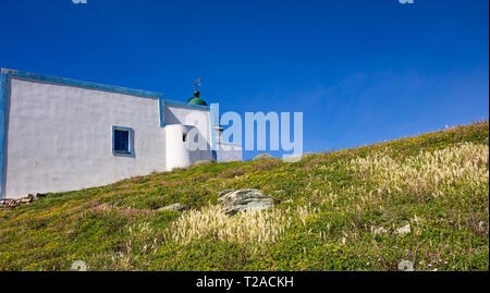 Griechenland. Kea Insel Leuchtturm. Weiße Farbe Gebäude, bunte Blumen auf grünem Gras, blau klar Himmel Hintergrund Stockfoto