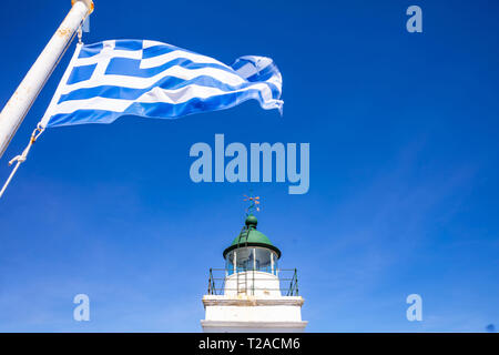 Griechenland. Kea Insel Leuchtturm. Griechische Flagge Schwenkten am klaren, blauen Himmel Hintergrund Stockfoto