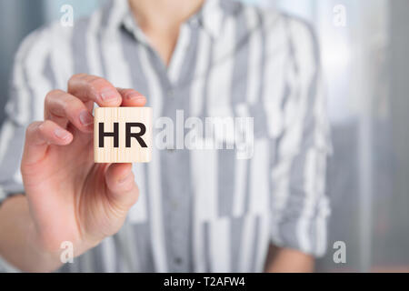 Hand der weiblichen Holding Holz cube Block mit Buchstaben HR. Menschliche Ressourcen und Personal Einstellung Konzept Stockfoto