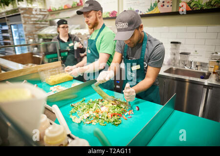 Irische FRISCH HÄCKSLER Salat zum Mitnehmen store Manchester für Ihren ersten Store in England Arbeiter mit einem mezzaluna Messer ausgewählt Stockfoto