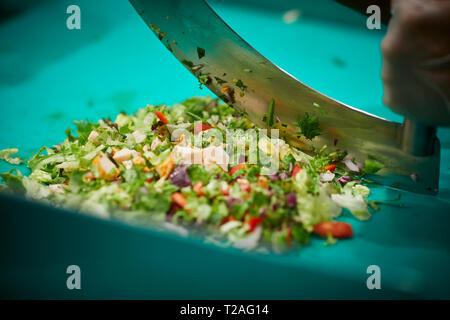 Irische FRISCH HÄCKSLER Salat zum Mitnehmen store Manchester für Ihren ersten Store in England Arbeiter mit einem mezzaluna Messer ausgewählt Stockfoto