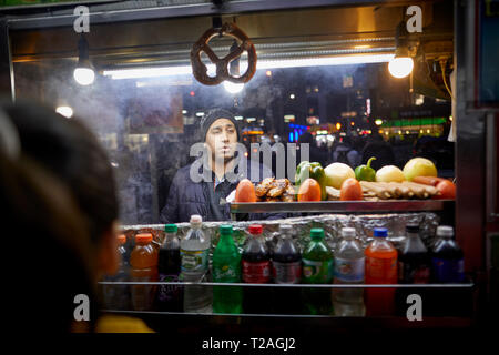 Asiatische Einwanderer New York Manhattan street Hersteller Verkauf von seinem Hot Dog cart Stockfoto