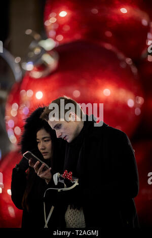 Große rote übergroße Riese christbaumkugeln Christbaumschmuck, 6. Avenue, Manhattan, New York bei Nacht Stockfoto