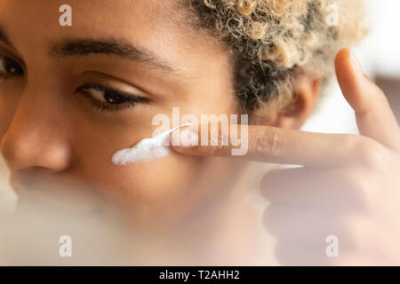 Junge Frau, die Anwendung der Feuchtigkeitscreme Stockfoto