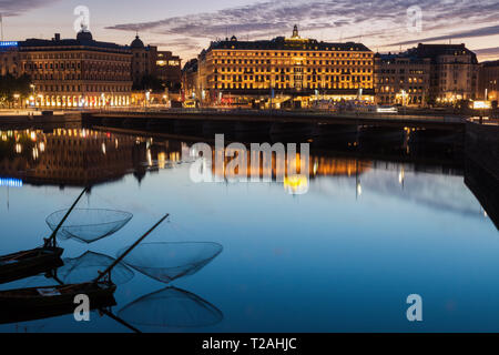 Gebäude, die durch Fluss bei Sonnenuntergang in Stockholm, Schweden Stockfoto