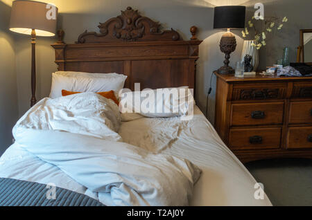 Hoch Blick von oben ein Schlafzimmer am Morgen Szene mit einem geräumten ungemacht Doppelbett in einem luxuriösen Schlafzimmer Stockfoto