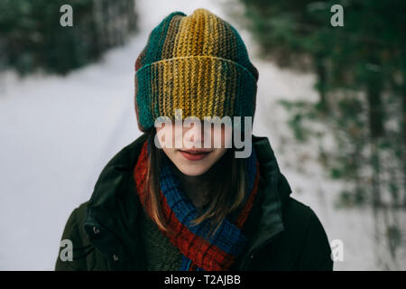 Junges Mädchen mit bunten Schirmmütze im Winter Stockfoto