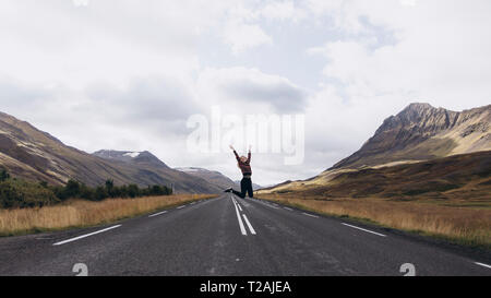 Frau springen auf der Autobahn in Island Stockfoto