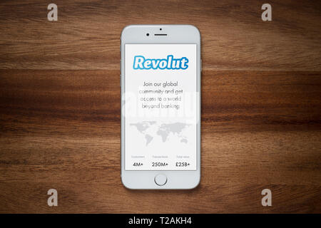 Ein iPhone mit der Revolut Website beruht auf einem einfachen Holztisch (nur redaktionelle Nutzung). Stockfoto