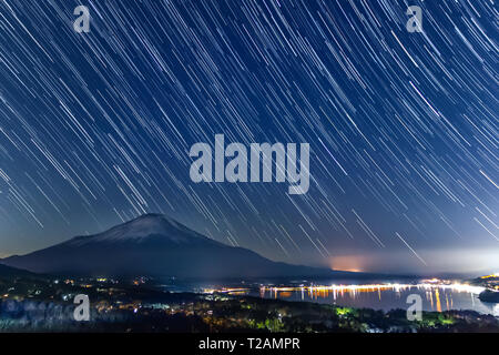 Nachtansicht des Mount Fuji mit sternspuren von Lake Yamanaka im Winter. Stockfoto