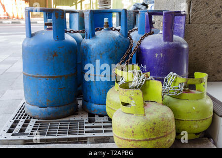 Mehrfarbige und unterschiedlich große Gasflaschen auf der Straße. Flaschen mit Flüssiggas (LPG), Propan - Butan für zu Hause. Bali Stockfoto