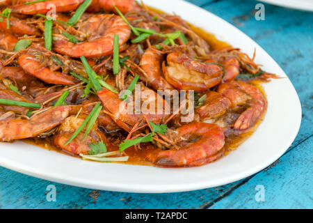 Garnelen in einer Sauce mit Kräutern auf Holztisch - ein traditionelles Gericht in Sri Lanka. Stockfoto