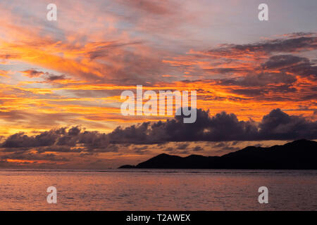 Ein dramatischer Sonnenuntergang über der Insel Praslin von La Digue, Seychellen Stockfoto