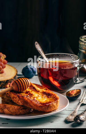 Gesundes Frühstück Konzept. French Toast mit Honig, Früchte und Tee über weiß Holz- Hintergrund Stockfoto