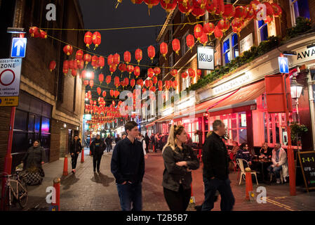 LONDON, UK, 22. MÄRZ 2019: Touristen und Einheimische zu Fuß auf den Straßen von Chinatown in Soho in der Nacht, eine große Attraktion und Party statt der c Stockfoto