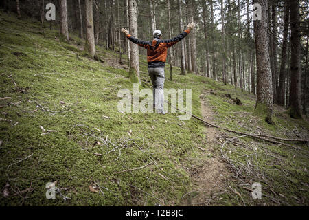 Ein Trekker wandern solo unter den Wald in ein bewölkter Tag Stockfoto