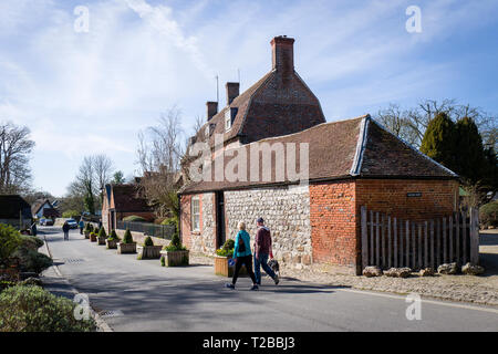 Touristen Paar erkunden Dorf Avebury in Wiltshire England UK vorbei Manor Farm Stockfoto