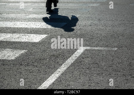 Schatten des Menschen überqueren die Straße Stockfoto